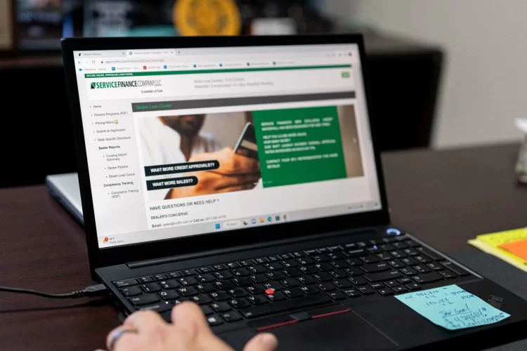 homeowner in Central Florida using a laptop to access financing support for thier next roofing project.